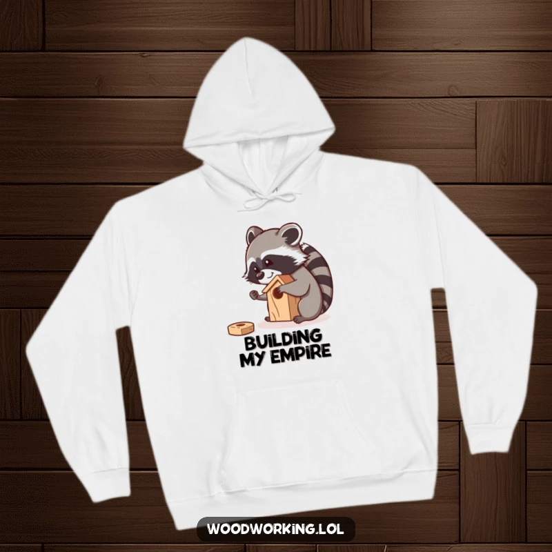 Funny raccoon meticulously sanding a small wooden birdhouse with a smile, depicted on a comfortable hoodie.